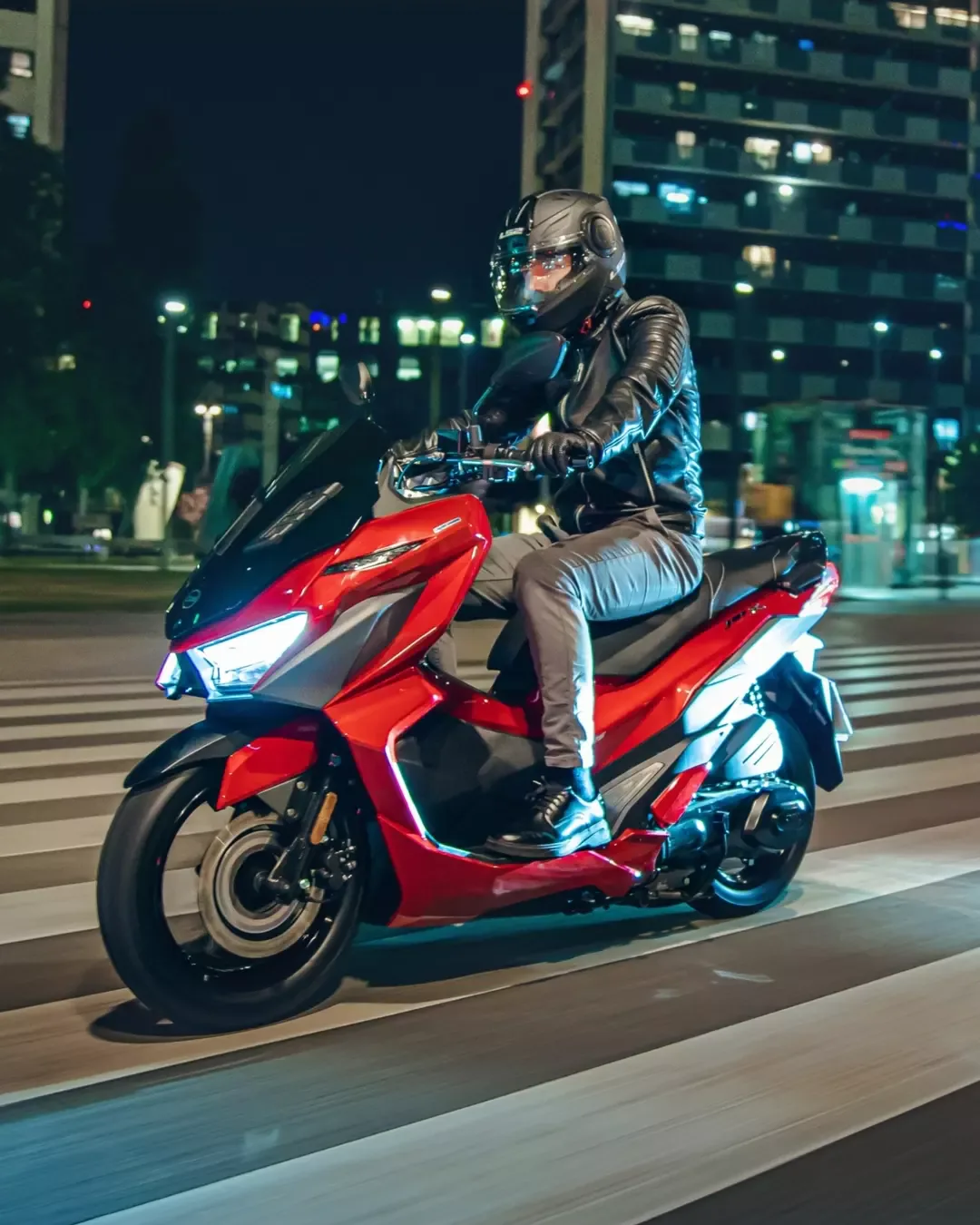 Crveni SYM JET X 125 u gradskoj vožnji